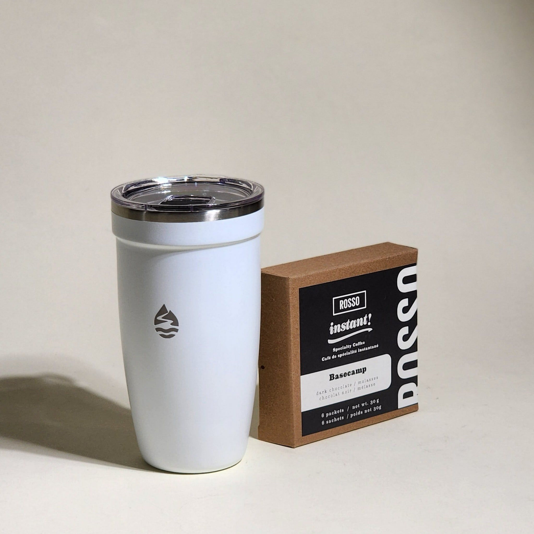 Rosso Coffee Roasters' Basecamp Instant Coffee: a rich blend with dark chocolate and molasses notes. Freeze-dried for flavor preservation. Six compostable packets per box. Ideal for travelers and adventurers.