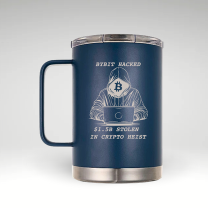 Alt text: A navy blue insulated coffee mug with a handle and a clear lid. The mug features an engraved design of a hooded figure using a laptop, with a Bitcoin logo covering their face. Above the figure, the text reads "BYBIT HACKED," and below, it states "$1.5B STOLEN IN CRYPTO HEIST." The engraving is in a light color, contrasting with the dark blue mug. 