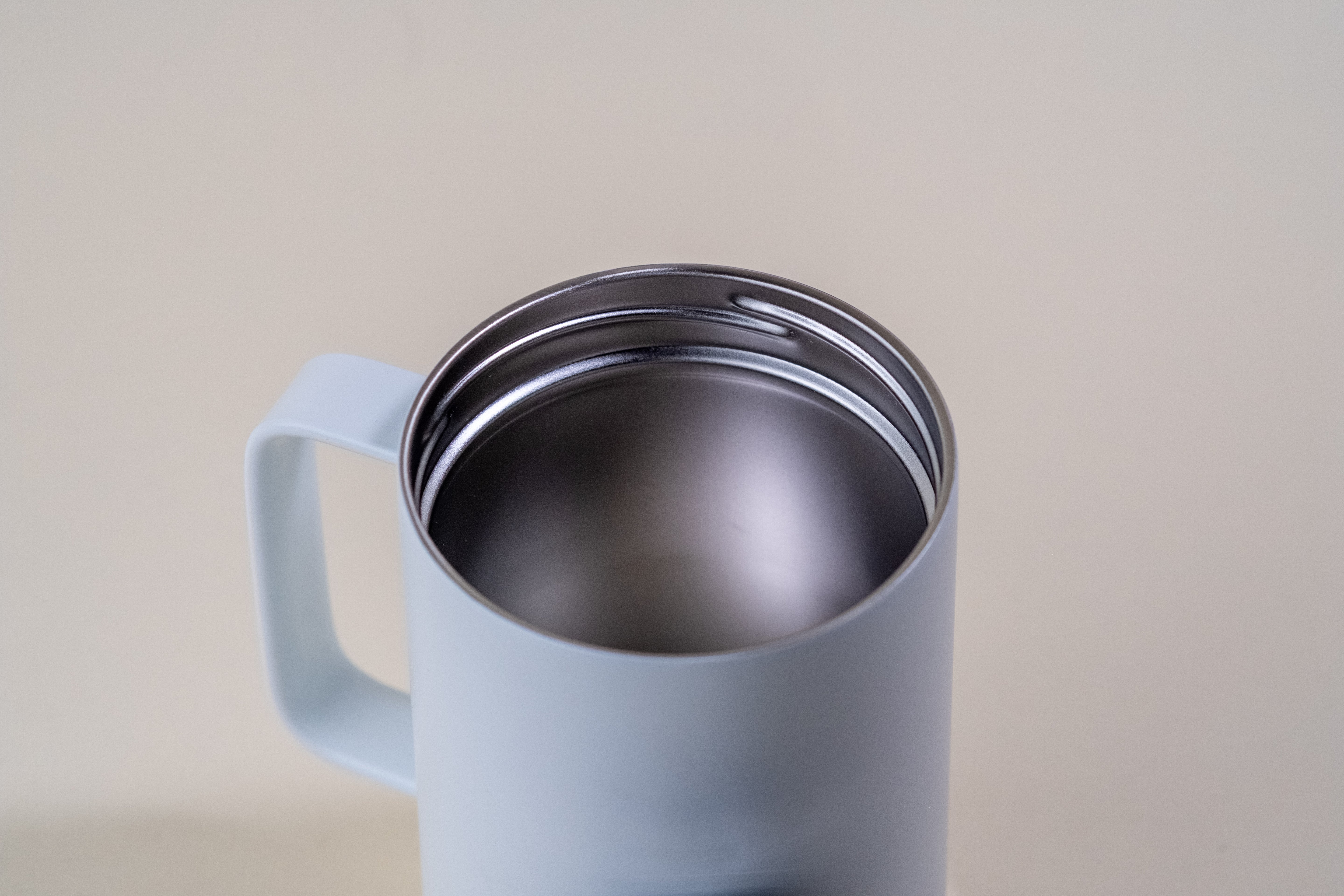 Close-up of a stainless steel insulated mug interior, showcasing its double-wall vacuum insulation for superior heat and cold retention. The durable BPA-free design keeps beverages hot for hours and cold all day, making it perfect for coffee, tea, or iced drinks.