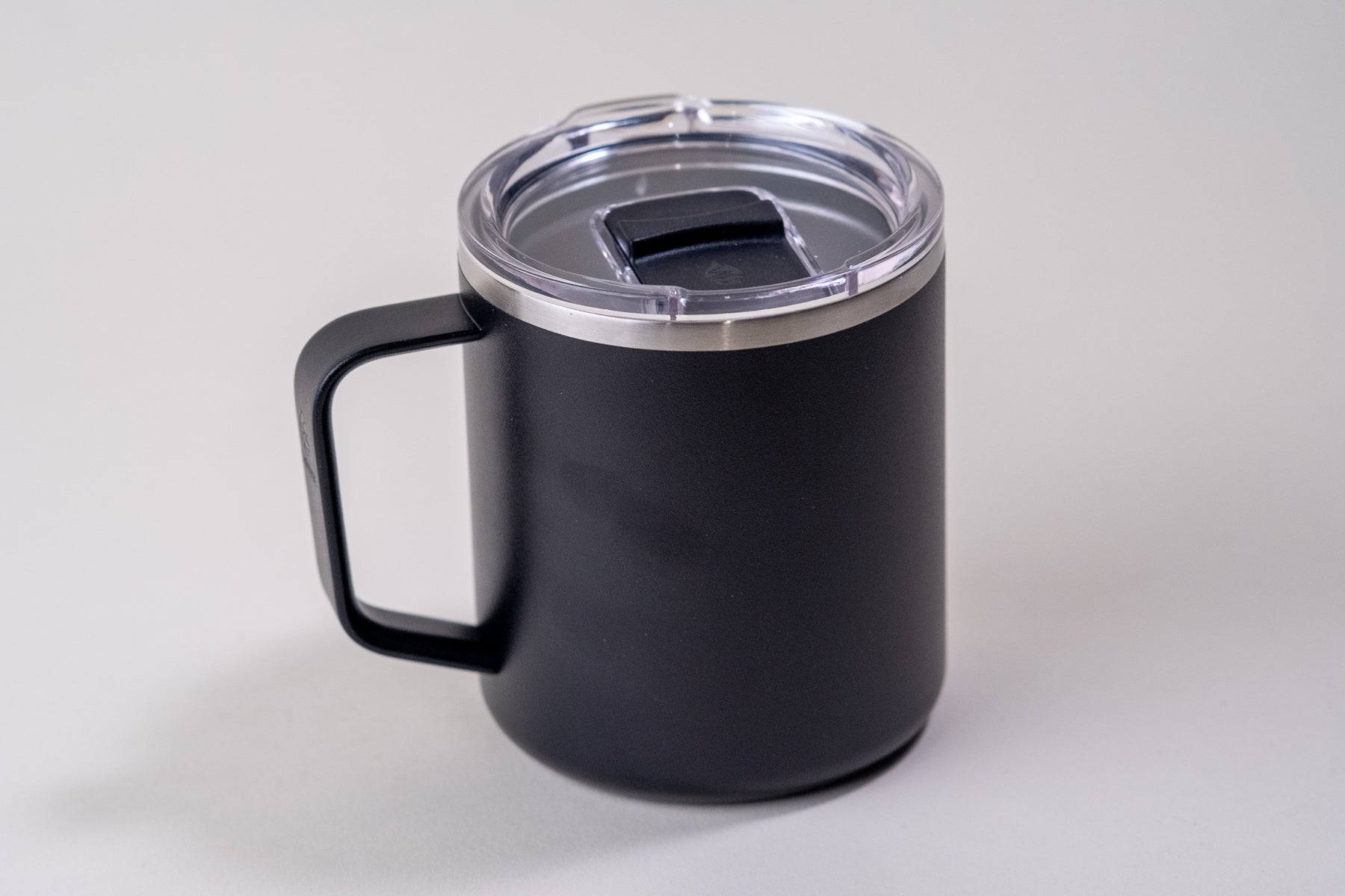 Black insulated coffee mug with a sturdy handle and a clear spill-resistant lid. Stainless steel, double-wall vacuum mug designed to keep beverages hot or cold for hours.