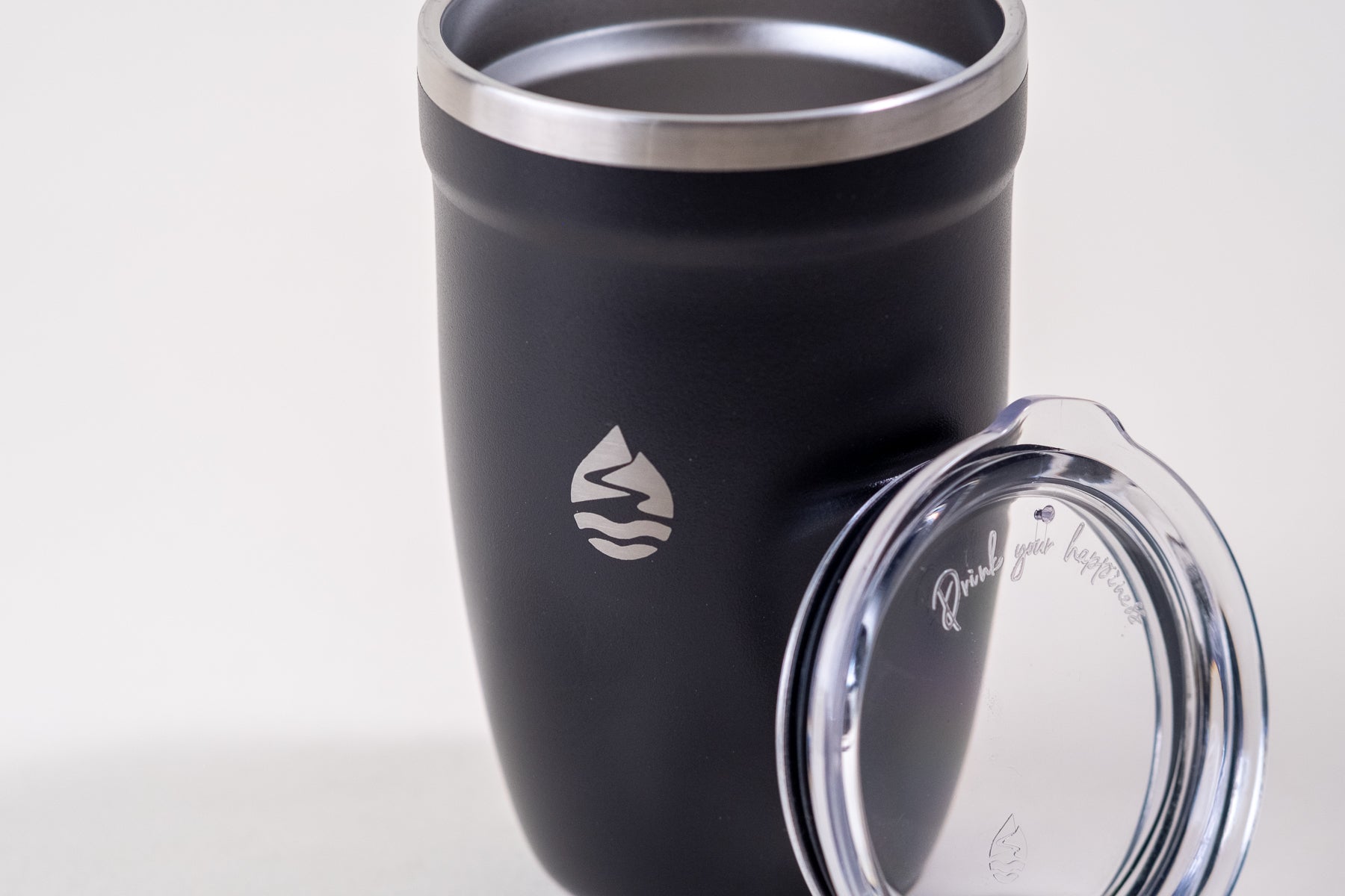 Black insulated tumbler with a stainless steel rim and a clear spill-resistant lid. Lamose travel mug designed for hot and cold beverages, featuring an engraved logo and motivational quote.