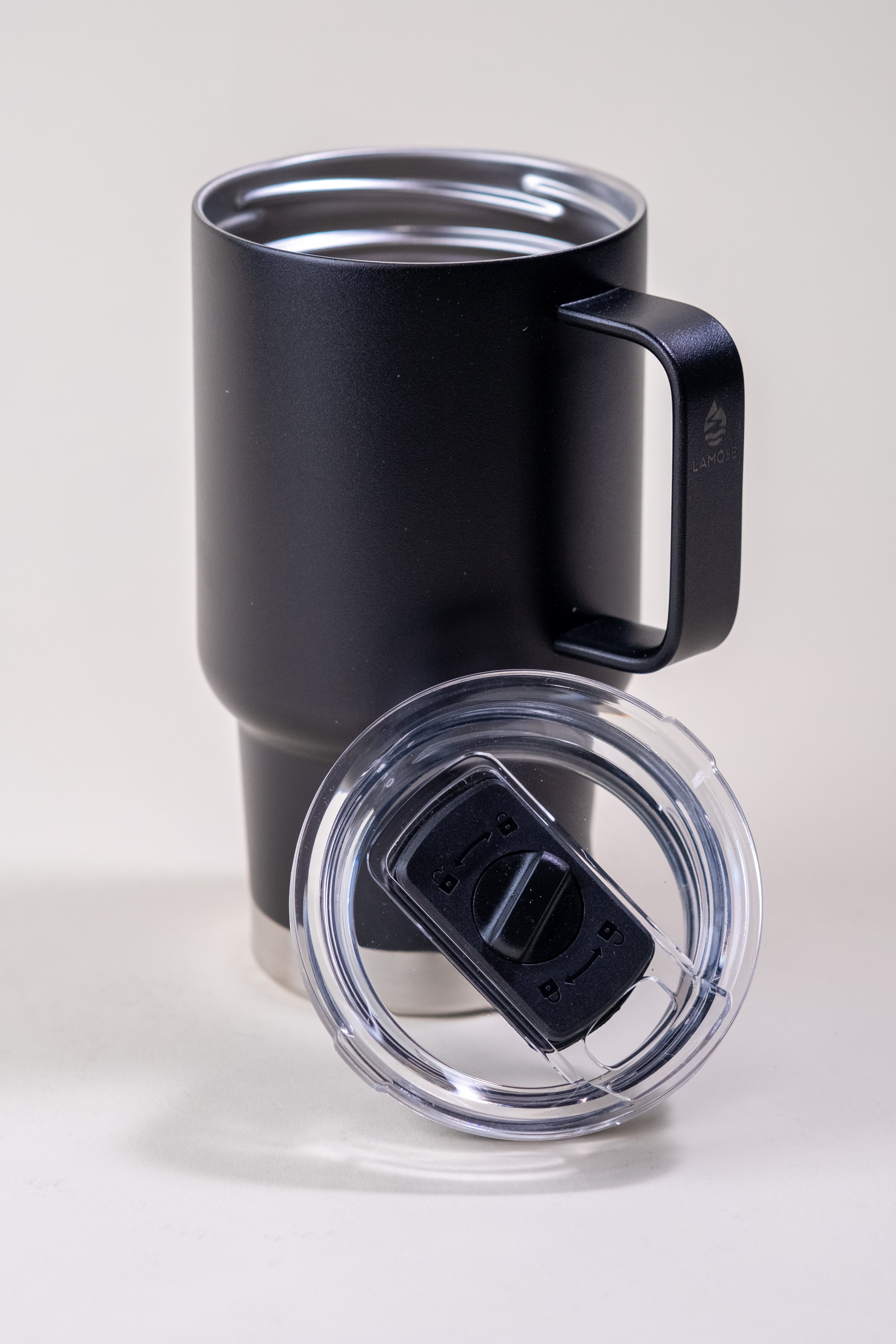 Black insulated travel mug with ergonomic handle and leak-resistant lid. Features a stainless steel double-wall design for hot and cold drinks.