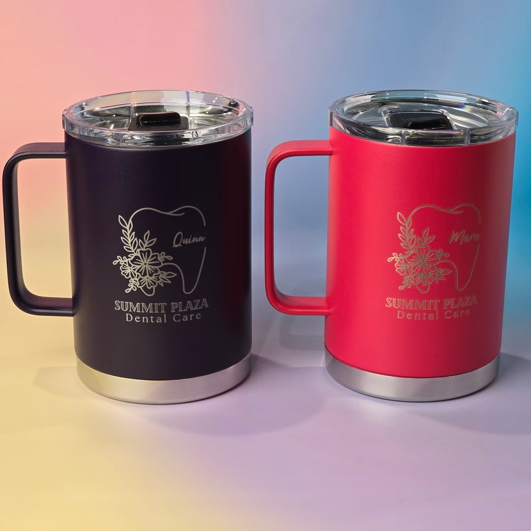 Two custom-engraved insulated mugs in deep purple and vibrant red, featuring the ‘Summit Plaza Dental Care’ logo with floral tooth design. 