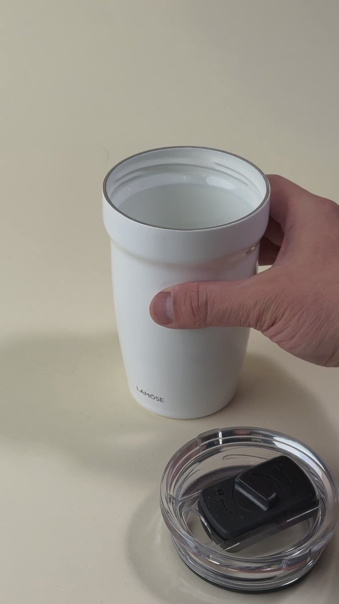 Load video: White insulated tumbler with a stainless steel interior and a removed spill-resistant lid. Double-wall vacuum design for keeping beverages hot or cold.