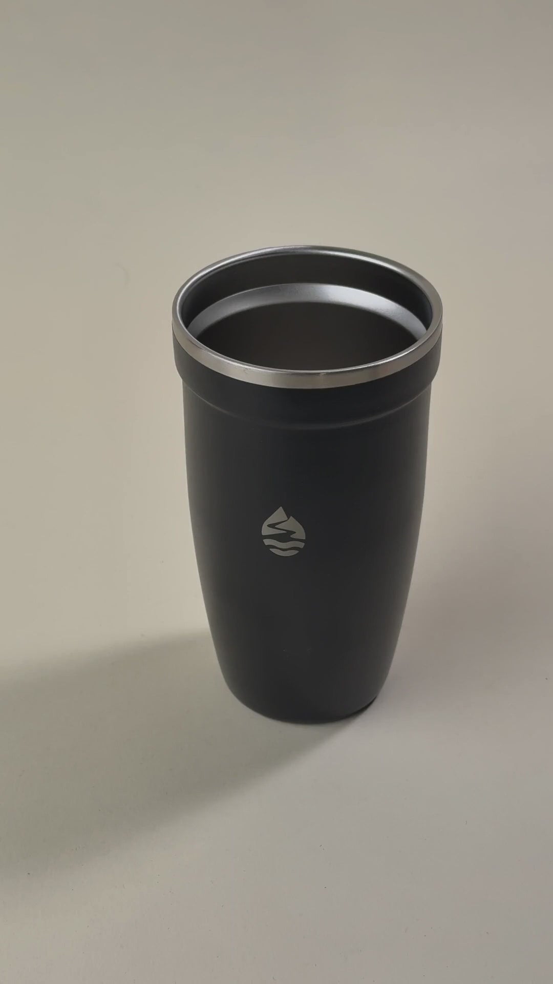 Load video: Hand holding a transparent spill-proof lid over a black insulated tumbler, showcasing its secure and leak-resistant design.