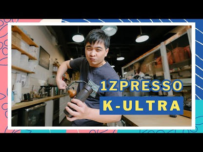 1Zpresso K-Ultra manual coffee grinder with foldable handle, finer adjustment mechanism (10 numbers/100 clicks), and rounded body for comfort. Suitable for all brewing methods including espresso. Package includes grinder, cleaning brush, rubber grip, air blower, and case.