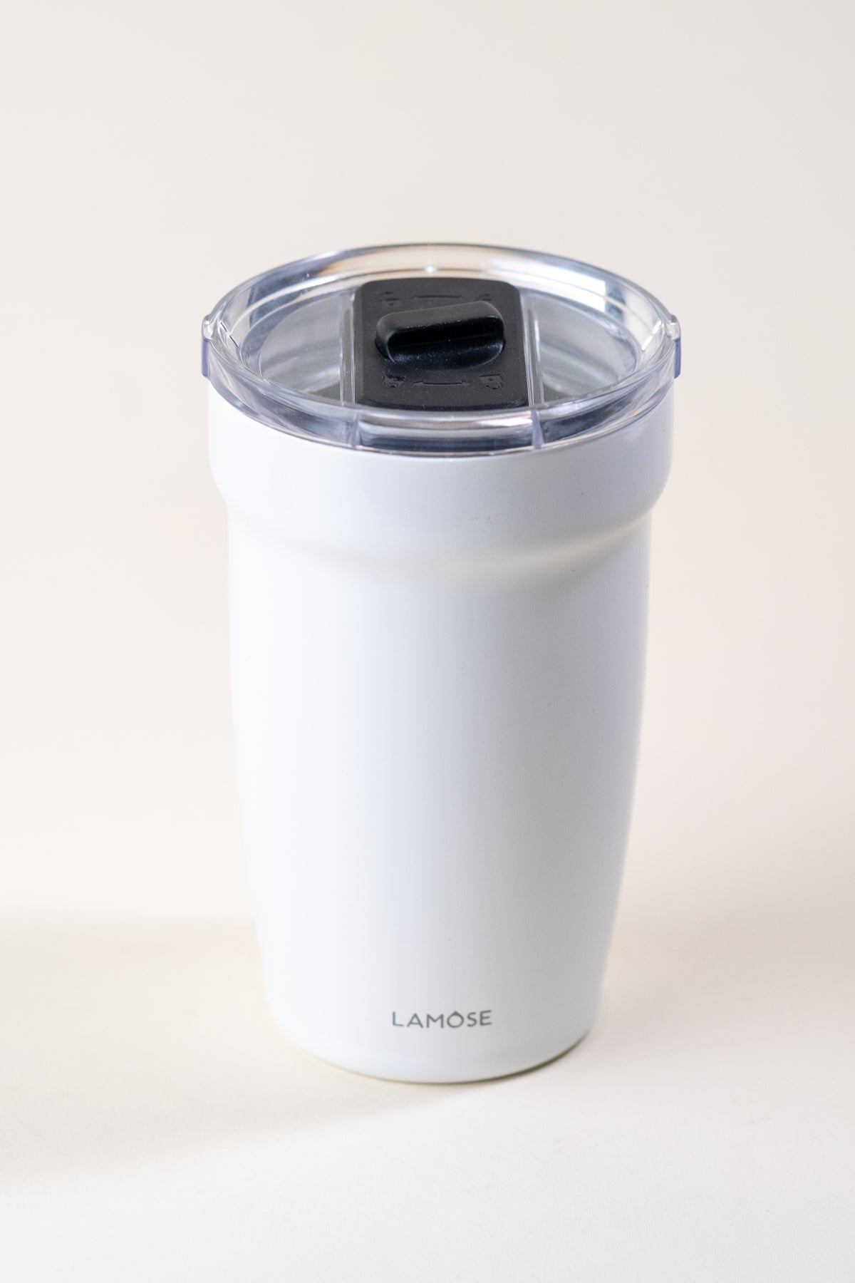 White enamel-coated insulated tumbler with a clear spill-resistant lid. Durable stainless steel travel mug by Lamose, designed to keep beverages hot or cold.